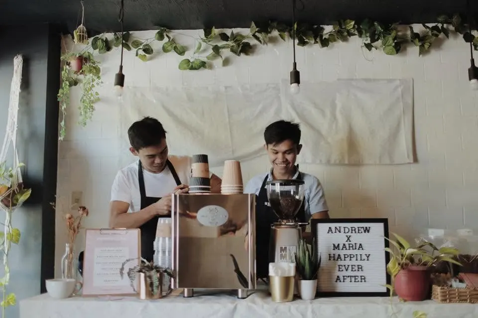 Two baristas behind an early pop-up coffee bar